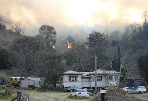 Fire and Emergency crew battle bushfire near a house in the rural town of Canungra in the Scenic Rim region of South East Queensland, Friday, September 6, 2019. (AAP Image/Regi Varghese)