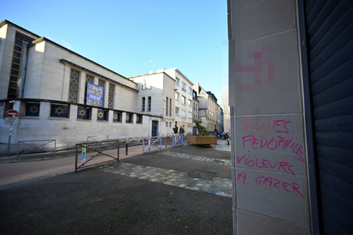 A swastika and a graffiti reading "Jews pedophiles, rapists to be gassed" on a wall in front of the synagogue.