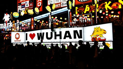 People pass by the light box, which says is "I love Wuhan", on pedestrian street Jianghan Road during New Year's Eve celebrations on December 31, 2022 in Wuhan, China. 