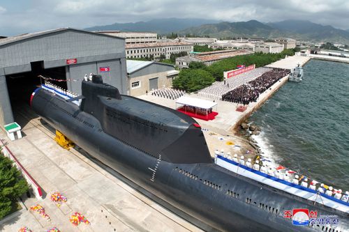 People attend what North Korean state media report was the country's launching ceremony for a new tactical nuclear attack submarine, in North Korea, in this handout image released on September 8.