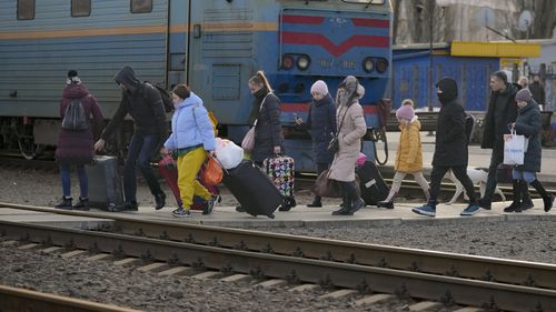 People walk to a platform in Kramatorsk, the Donetsk region, eastern Ukraine, with luggage.