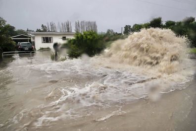 Water gushes from a storm drain access port on a street in Te Awanga, southwest of Auckland, New Zealand, Tuesday, Feb. 14, 2023. The New Zealand government declared a state of emergency across the country's North Island, which has been battered by Cyclone Gabrielle. (Warren Buckland/Hawkes Bay Today via AP)