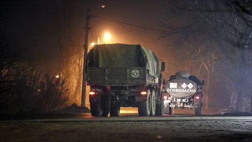 Military trucks move down a street outside Donetsk, the territory controlled by pro-Russian militants, eastern Ukraine, late Tuesday, Feb. 22, 2022. Russian President Vladimir Putin has raised the stakes in the Ukraine standoff by recognizing the independence of rebel regions in the country's east. A key question now is whether he will stop at that or try to move deeper into Ukraine. (AP Photo)