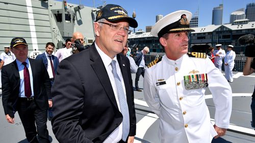 Prime Minister Scott Morrison and Minister for Defence Christopher Pyne (left) greet Navy personnel onboard HMAS Brisbane after a commissioning ceremony in Sydney, Saturday, Oct. 27, 2018. 