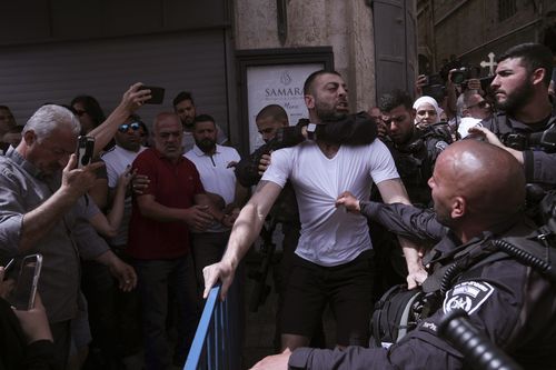 Israeli police detain a man during the funeral for slain Al Jazeera veteran journalist Shireen Abu Akleh in the Old City of Jerusalem, Friday, May 13, 2022. Abu Akleh, a Palestinian-American reporter who covered the Mideast conflict for more than 25 years, was shot dead Wednesday during an Israeli military raid in the West Bank town of Jenin.(AP Photo/Mahmoud Illean)