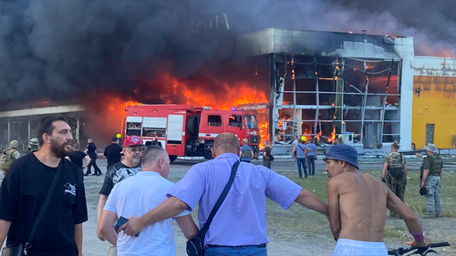 Oamenii urmăresc suflantele de fum după ce o rachetă rusă a lovit un mall aglomerat, în Kremenchug, Ucraina, luni, 27 iunie 2022. 