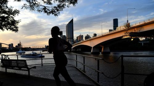 A woman jogs along the Brisbane River in Queensland. 