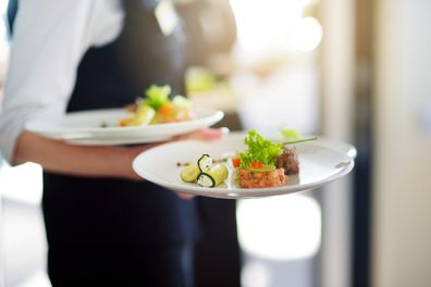 restaurant server carrying plates