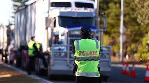 Queensland Police stop trucks at the Queensland border with NSW.