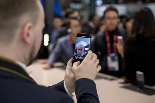 A man clicks his selfie with a smartphone during the Mobile World Congress. (AAP)