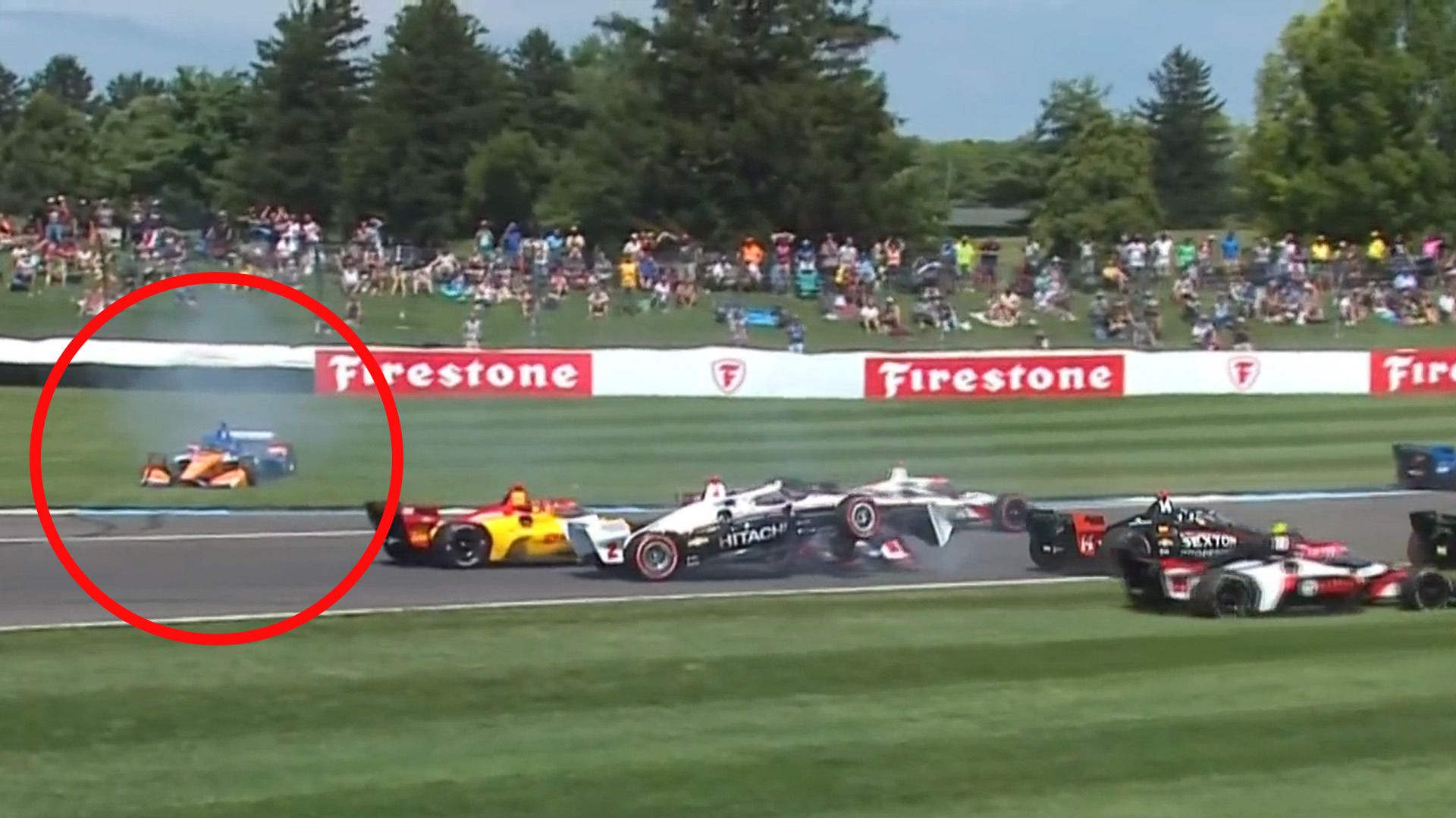 Scott Dixon (circled) spins off in the grass while Josef Newgarden mounts the nose cone of Marcus Armstrong.