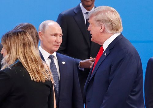 Trump walks past Russia's President Vladimir Putin as they gather for the group photo at the start of the G20 summit in Buenos Aires, Argentina.