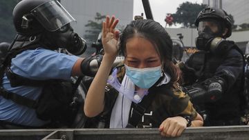 A protester is confronted by riot police during a massive demonstration outside the Legislative Council in Hong Kong 