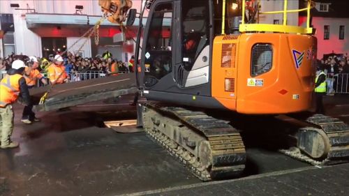 It took about two hours for road workers to carefully dig through bitumen before machinery lifted the lid on Parr's temporary underground home. Picture: 9NEWS