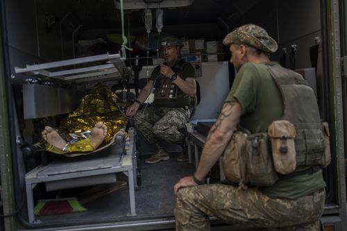 An injured Ukrainian servicemen is transferred to a medical facility after getting an emergency medical treatment in the  Donetsk region, eastern Ukraine, Tuesday, June 7, 2022.