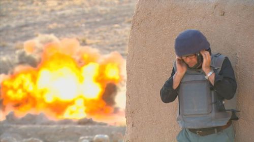 Nine's Mark Burrows reacts to an IED going off in a controlled explosion in Afghanistan. 
