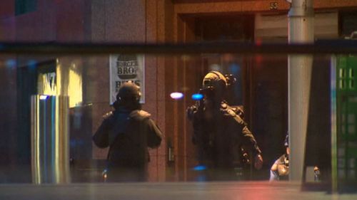Two Special Operations Group officers stand by the Lindt cafe in Martin Place, nine hours after two female hostages escaped. (9NEWS)