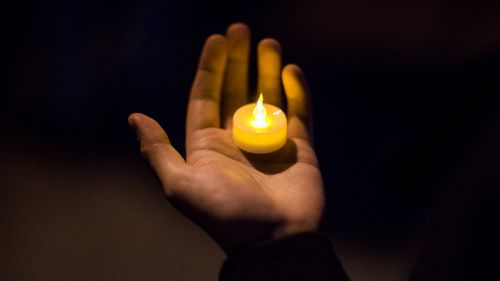 A man holds a candle during an interfaith vigil for peace in response to Manhattan Attack at Foley square. (AAP)