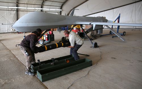 Contract workers load a Hellfire missile onto a US Air Force MQ-1B Predator unmanned aerial vehicle (UAV), at a secret air base in the Persian Gulf region. 