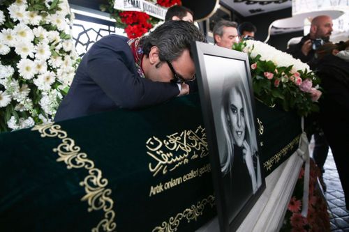 Burcu Gundogar Urfali broke down over top of his wife's coffin at the joint funeral service. (Getty)