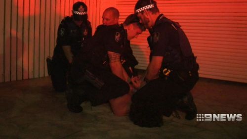 Paramedics work with police to subdue a patient. (9NEWS)