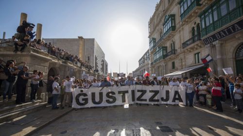 A banner reading "justice" opens a rally in Malta to honor an anti-corruption reporter Daphne Caruana Galizia, killed by a car bomb on Oct. 16, in the capital city of Malta, Valletta, Sunday, Oct. 22, 2017. (AP Photo/Rene Rossignaud)