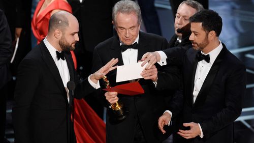 La La Land producer Warren Horowitz (left), presenter Warren Beatty and host Jimmy Kimmel check the envelope. (AAP)