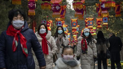 Chinese women and a child all wear protective masks after celebrations for the Chinese New Year and Spring Festival were cancelled by authorities on January 25, 2020 in Beijing, China. 
