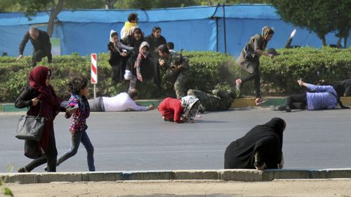 Civilians try to take shelter in a shooting scene, during a military parade marking the 38th anniversary of Iraq's 1980 invasion of Iran, in the southwestern city of Ahvaz, Iran. (AP)