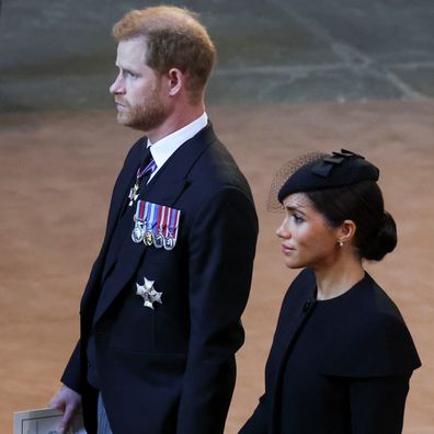 LONDON, ENGLAND - SEPTEMBER 14: Prince Harry, Duke of Sussex and Meghan, Duchess of Sussex walk as procession with the coffin of Britain's Queen Elizabeth arrives at Westminster Hall from Buckingham Palace for her lying in state, on September 14, 2022 in London, United Kingdom. Queen Elizabeth II's coffin is taken in procession on a Gun Carriage of The King's Troop Royal Horse Artillery from Buckingham Palace to Westminster Hall where she will lay in state until the early morning of her funeral.