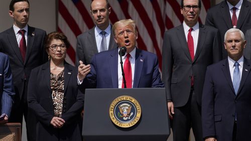 President Donald Trump speaks during a news conference in the Rose Garden of the White House, Friday, June 5, 2020, in Washington. Front row from left, Small Business Administration administrator Jovita Carranza, Trump, and Vice President Mike Pence. Back row from left, member of Council of Economic Advisers Tyler Goodspeed, Labor Secretary Eugene Scalia, Treasury Secretary Steven Mnuchin, and Chairman of the Council of Economic Advisers Tomas Philipson