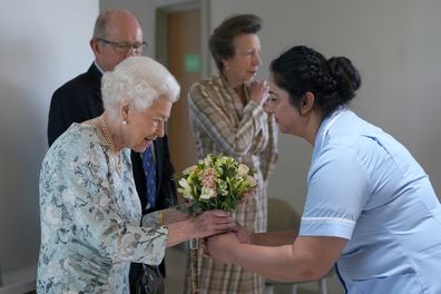 Queen Elizabeth II receives flowers during a visit to officially open the new building at Thames Hospice on July 15, 2022 in Maidenhead, England. 