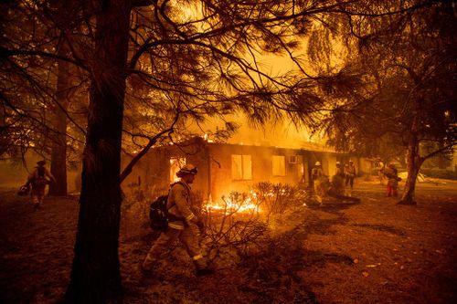 More than 5500 fire personnel were battling the blaze that covered 590 square kilometres and was halfway contained, officials said.
