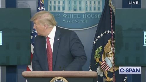 Mr Trump is told of an incident and led from the room.