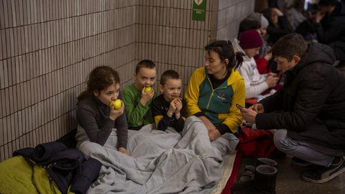 Une famille est assise dans le métro de Kiev, l'utilisant comme abri anti-bombes à Kiev, en Ukraine. 