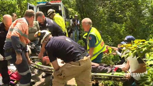 Emergency crews had to rig ropes up to Paul Robinson's stretcher to haul him up the hill. (9NEWS)