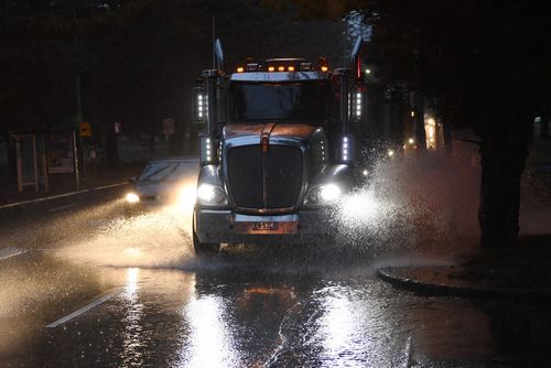 Morning commuter traffic negotiate the flooded Grand Parade at Brighton Le Sands in Sydney.(AAP Image/Dean Lewins) 