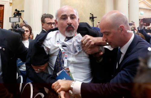 An apparent protester has been escorted out of a joint press conference between US President Donald Trump and Russian President Vladimir Putin. Image: AP