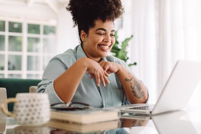 Happy woman video calling using laptop