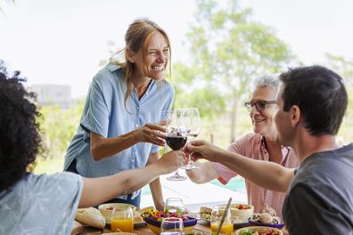 Happy family toasting wine glasses while sitting at table for lunch