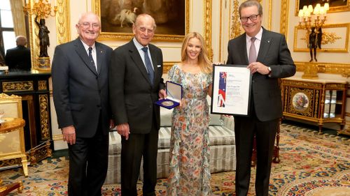 The Duke of Edinburgh presents Kylie Minogue with the Britain-Australia Society Award for 2016, with Britain-Australia Society chairman Peter Benson and Australian High Commissioner to the the UK Alexander Downer. (AAP)