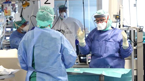 Doctors and healthcare workers in an Intensive Care Unit in Italy wear overalls and other protective equipment to prevent COVID-19 infection.    