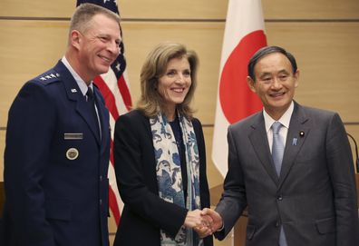 Japanese Chief Cabinet Secretary Yoshihide Suga, right, shakes hands with U.S. Ambassador to Japan Caroline Kennedy as Lt. Gen. John Dolan, Commander of U.S. Forces Japan, left, smiles after their joint press conference at Japanese Prime Minister's official residence in Tokyo, Friday, Dec. 4, 2015. (AP Photo/Koji Sasahara,Pool)