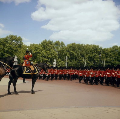 The Queen salutes Troops as they march towards Horse Guards Parade for Trooping the Colour in 1973.