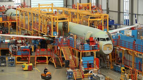 A partially-finished passenger plane of the A320 series stands in an assembly hall at the Airbus factory