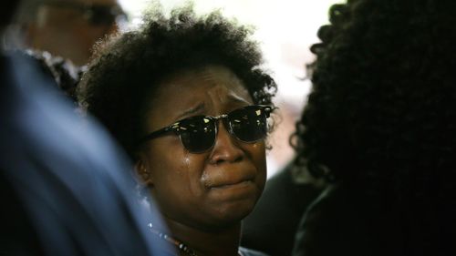 A family member weeps while joining the mourners. (AAP)