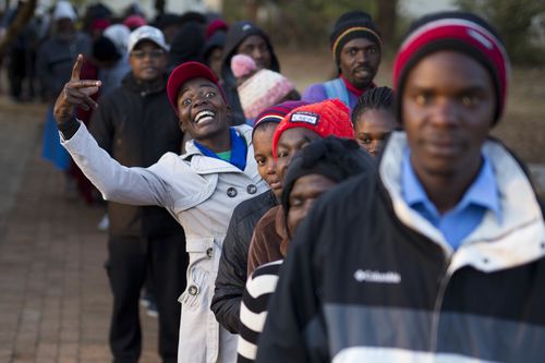 Zimbabweans line up to vote at the Fitchela primary school in Kwekwe, Zimbabwe, Monday, July 30, 2018. The vote will be a first for the southern African nation following a military takeover and the ousting of former longterm leader Robert Mugabe. (AP Photo/Jerome Delay)