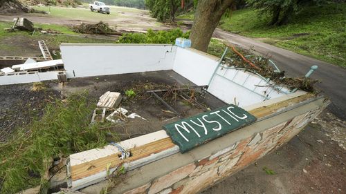 A Camp Mystic sign is seen near the entrance to the establishment along the banks of the Guadalupe River after a flash flood swept through the area in Hunt, Texas, Saturday, July 5, 2025. (AP Photo/Julio Cortez)