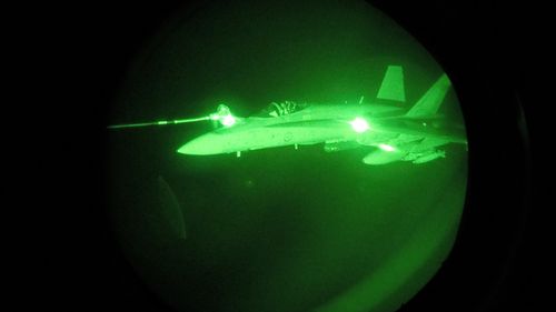 Night Vision image of an Australian F/A-18A Hornet refuelling from a Royal Australian Air Force KC-30A Multi Role Tanker Transport aircraft during a mission over Syria. 
