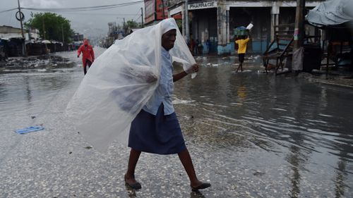 A woman protects herself from the rain with plastic after Hurricane Matthew touched down in Haiti. (AFP)
